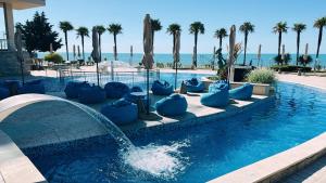 a swimming pool with a fountain in a resort at Sandy Bay Resort - All Inclusive Private Beach Hotel in Sveti Vlas