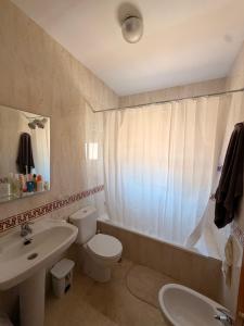a bathroom with a toilet and a sink and a tub at Chalet Matalascañas in Matalascañas +12 photos