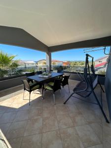 a dining room with a table and chairs on a patio at Apartments Duda in Vir