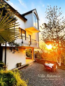 a villa with a table and chairs and the sunset at Sea View Private Villa in Batumi