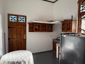 a kitchen with a black refrigerator and wooden cabinets at Stay Home Arugambay in Arugam Bay +1 photo