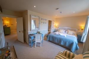 a bedroom with a bed and a table and a chair at The Market Tavern in Bampton