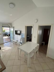 a living room with a white table and a room at Apartments Duda in Vir