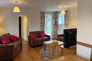 a living room with two couches and a tv at Walled garden cottage in Hassocks