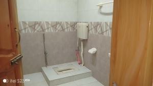 a bathroom with a toilet in the corner of the room at BHURBAN MOUNTAIN VIEW APARTMENTs in Murree