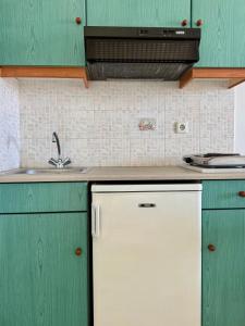 a kitchen with green cabinets and a sink at HOTEL KAPARI in Agia Anna Naxos +10 photos