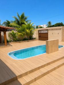 a swimming pool in a backyard with a wooden deck at Casa Nordestina in Nísia Floresta