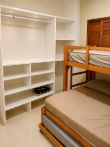 a bedroom with a bunk bed and shelves at Casa Nordestina in Nísia Floresta