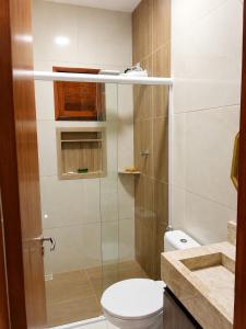 a bathroom with a toilet and a glass shower at Casa Nordestina in Nísia Floresta +5 photos