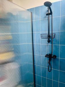 a blue tiled shower with a shower head on a wall at Sea View Private Villa in Batumi +50 photos
