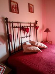 um quarto com uma cama vermelha com duas almofadas em Vilar dos Condes em Madeirã