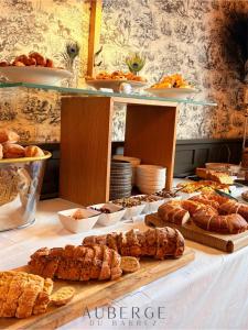 a table with various types of bread and pastries on it at Hotel Restaurant Auberge du Barrez Logis in Mur-de-Barrez