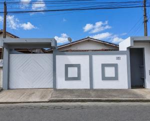 a white house with a white fence at Cantinho Da Go in Caraguatatuba