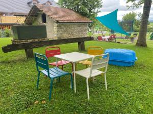 a table and chairs sitting in the grass at Gîte des oursons - Climatisé in Guyans-Durnes