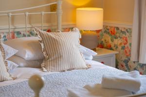 a bedroom with a bed with white sheets and a lamp at The Market Tavern in Bampton