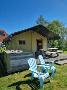 two chairs and a picnic table in front of a tent at Safaritent Aesgestate in Gauw