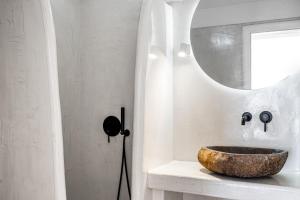 a bathroom with a stone sink and a mirror at Neraé Santorini in Imerovigli +49 photos