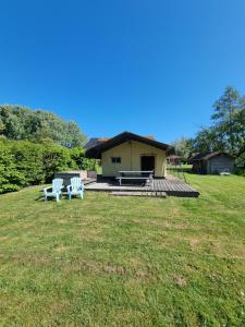 two chairs and a table and a house in a field at Safaritent Aesgestate in Gauw