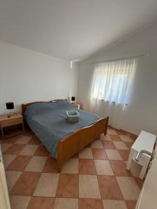 a bedroom with a bed and a window and a tiled floor at Apartments Duda in Vir