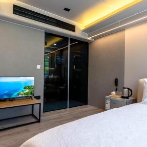 a bedroom with a large bed and a flat screen tv at Mesopotam Agrotourism Resort in Sarandë