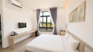 a bedroom with a white bed and a window at Khách sạn New Star 2 in Thiện Ngôn +6 photos