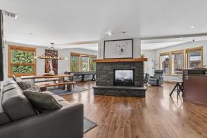 a living room with a fireplace and a couch at Rundle Cliffs Lodge by Canmore Premier in Canmore