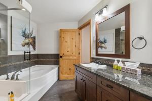 a bathroom with a tub and a large mirror at Rundle Cliffs Lodge by Canmore Premier in Canmore +27 photos