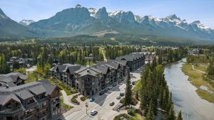 an aerial view of a resort with a river and mountains at Rundle Cliffs Lodge by Canmore Premier in Canmore