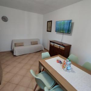 a living room with a table and chairs and a couch at Pauli's apartment in Valledoria