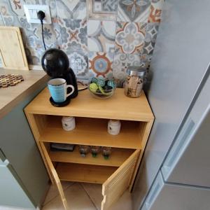 a small wooden cabinet in a kitchen with a cupboard at Pauli's apartment in Valledoria +21 photos