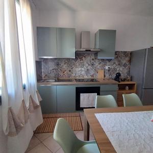 a kitchen with a table and chairs and a kitchen with a stove at Pauli's apartment in Valledoria