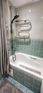 a bath tub in a bathroom with a shower at Spacious apartment with balcony in Tallinn +9 photos