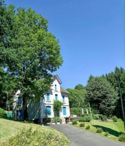 a white house with blue trim on a driveway at Ted et Breakfast in Corrèze
