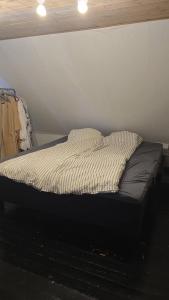 an unmade bed in a room with a wall at Casa Tolne in Sindal