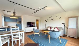 a living room and kitchen with a table and a couch at Gemütliches App in Westerland mit Hund in Süderende +12 photos