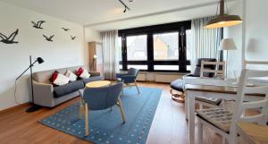 a living room with a couch and a table at Gemütliches App in Westerland mit Hund in Süderende