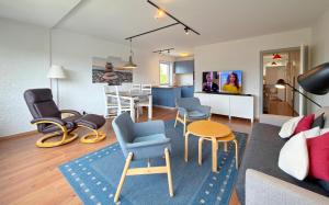 a living room with a couch and chairs and a table at Gemütliches App in Westerland mit Hund in Süderende