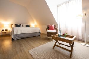 a bedroom with a bed and a chair and a table at The Little Guesthouse in Salzburg