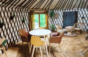 a room with a table and chairs in a yurt at Au Clères de yourte in Cléres