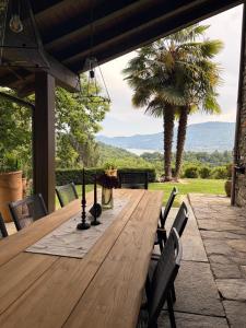 a wooden table on a patio with a palm tree at Rustico Villa Antonia with seaview and pool in Bieno