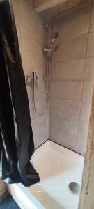 a shower with a shower head in a bathroom at Au Clères de yourte in Cléres