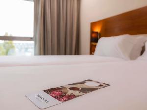 a hotel room with a magazine on a bed at Hotel Mercure Lisboa in Lisbon