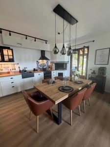 a large kitchen with a wooden table and chairs at Rustico Villa Antonia with seaview and pool in Bieno