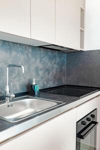 a kitchen with a sink and white cabinets at SeaScape Residence in Borsh +112 photos