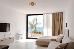 a living room with a bed and a large window at SeaScape Residence in Borsh