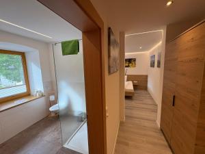 a bathroom with a walk in shower and a hallway at Frühstücks-Radpension Taurer-Thoman in Dellach im Drautal +49 photos