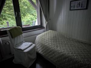 a bedroom with a bed and a chair and a window at Kleiner Fuchsbau in Kleinern