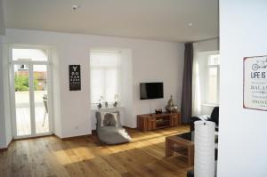 uma sala de estar com paredes brancas e pisos em madeira em Loft Style 3 Room Apartment + terrace em Villingen-Schwenningen