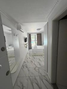 a large white room with two beds and a bathroom at Elois Apartments in Shëngjin +65 photos