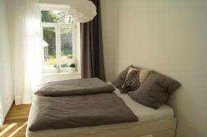 a bed with pillows on it in a room with a window at Loft Style 3 Room Apartment + terrace in Villingen-Schwenningen